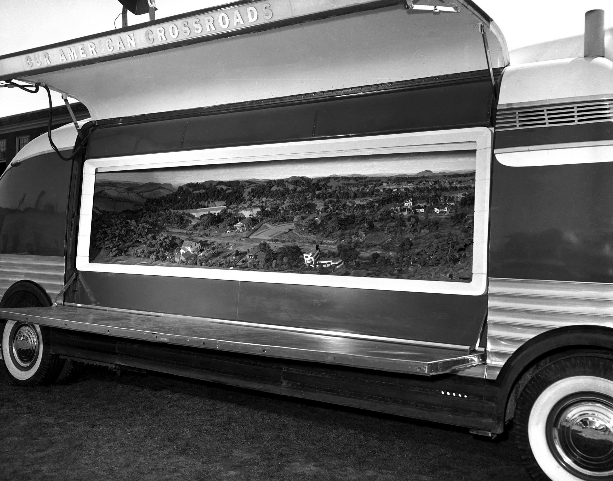 Historic photo showing a Futurliner with the side panels open to display the "Our American Crossroads" exhibit