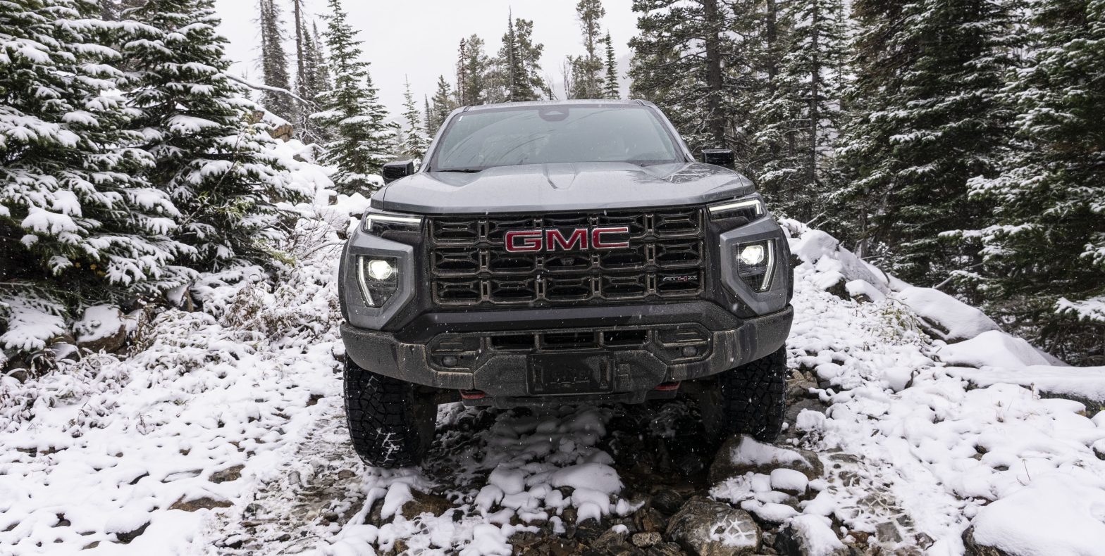 A straight on front end look at a GMC Canyon AT4X on a snowy mountain trail