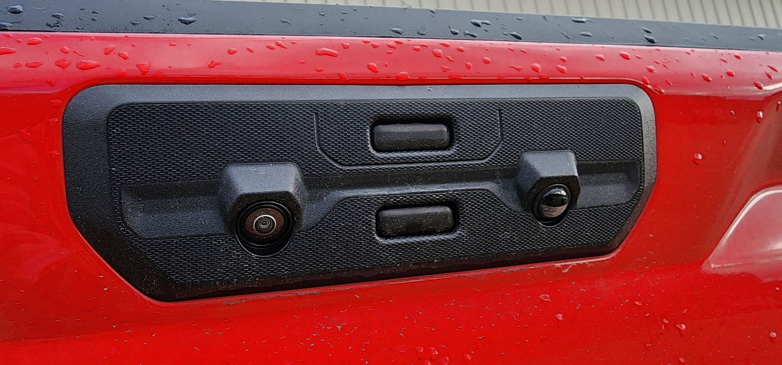 The tailgate release buttons on a Red Chevrolet Silverado with the Multi-Flex tailgate