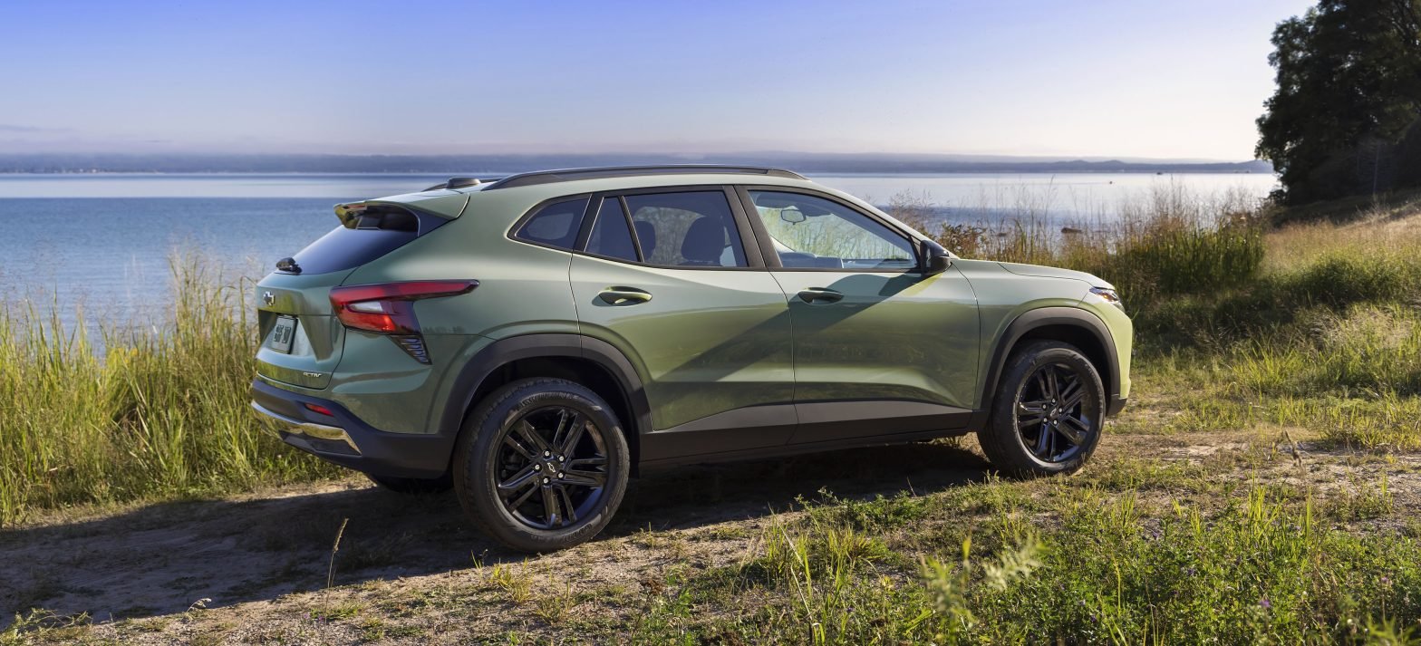 Passenger’s side view of Chevrolet Trax ACTIV in Cacti Green parked in front of a lake. Pre-production model shown. Actual production model may vary. Available in spring 2023. Cacti Green exterior color late availability.