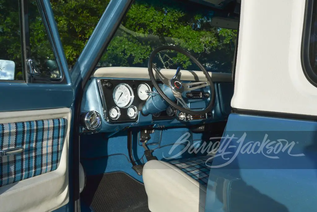 The interior is a masterpiece of craftsmanship, featuring custom leather blue and white plaid upholstery by the award-winning Jon Lind, set against a backdrop of leather-wrapped dash, console, and door panels.