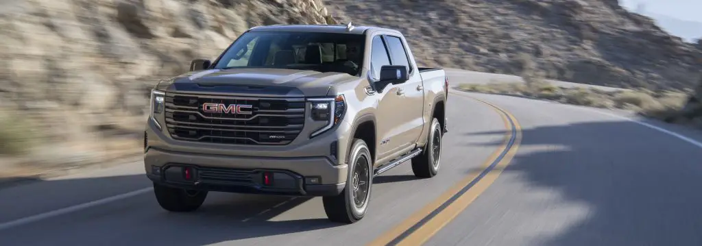 How Many Trucks Has Chevrolet and GMC Sold In 2024 So Far? It's Surprising 5 The 2023 GMC Sierra AT4X driving on pavement finished in Desert Sand Metallic.