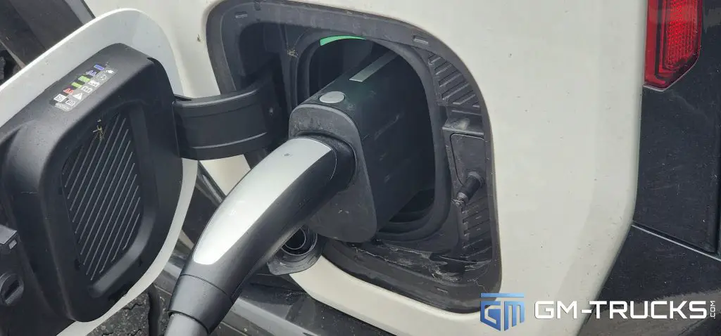 A Tesla Supercharger Magic Dock Connector charging on a GMC HUMMER EV
