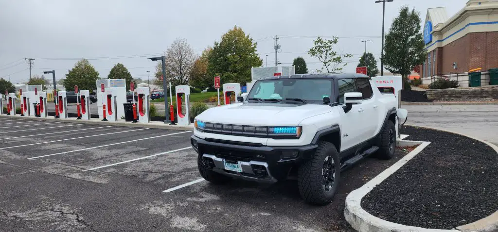 A HUMMER EV Charging at a Tesla Supercharger Station