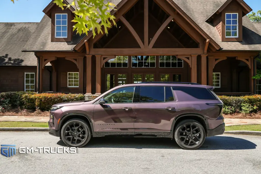 2024 Chevrolet Traverse parked in front of a rustic wood lodge. 
