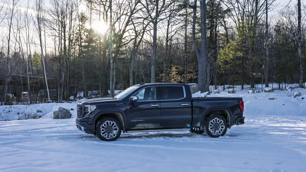 2021 GMC Sierra Denali with Duramax Diesel Engine parked in snowy woods during winter