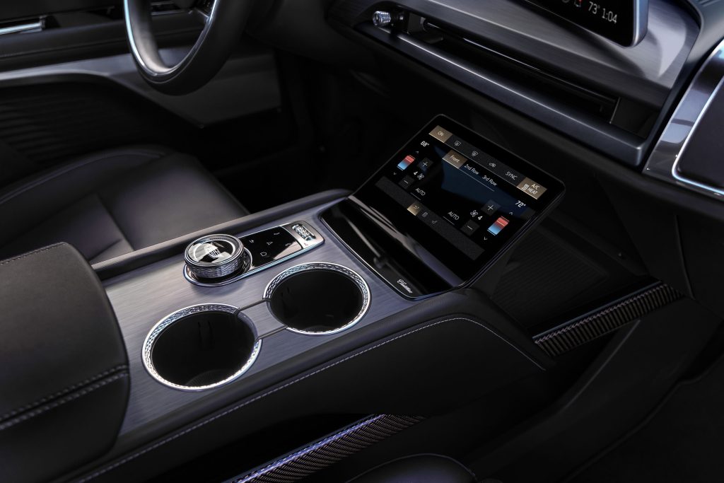 Cadillac's 2026 Vistiq EV: A Three-Row 'Baby Escalade' With 615 HP 4 Close-up of the 2026 Cadillac Vistiq EV center console with touchscreen climate controls and illuminated cupholders.