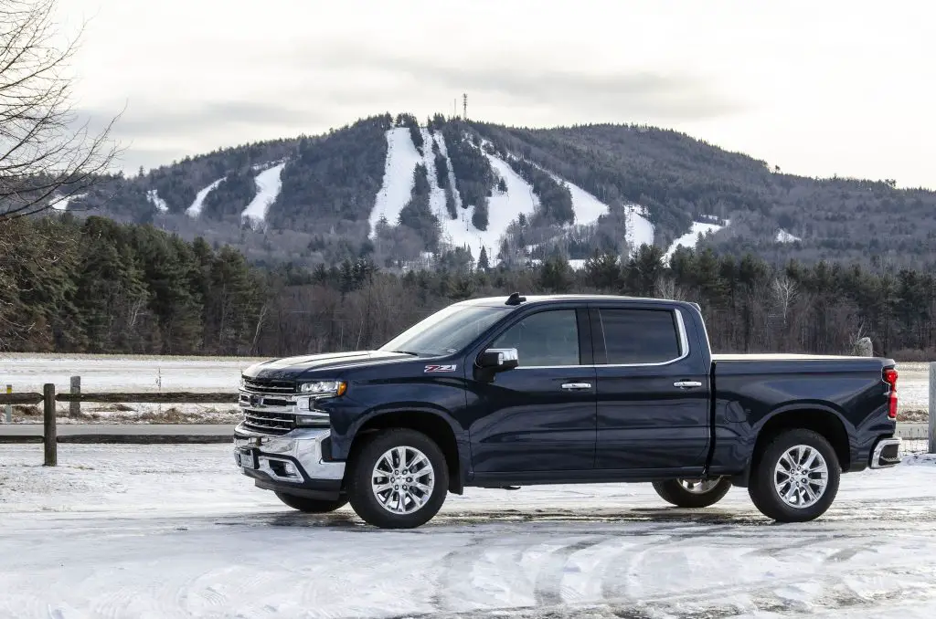 15 Years of Free Repairs? GM Will Cover Diesel Truck and SUV Transmission Lock Up Issues 2 Blue 2021 Chevrolet Silverado 1500 Z71 Diesel parked on snow with forest and mountain ski slopes in the background.