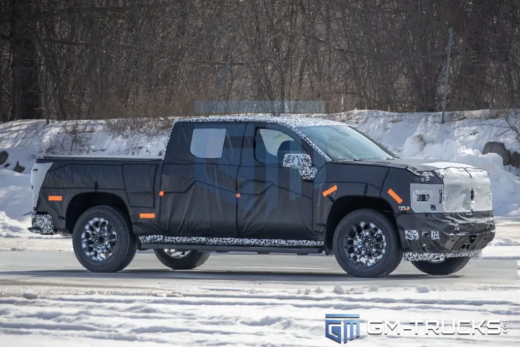 Camouflaged 2027 Chevrolet Silverado or GMC Sierra prototype undergoing winter testing, revealing updated bodywork, lighting, and platform changes.