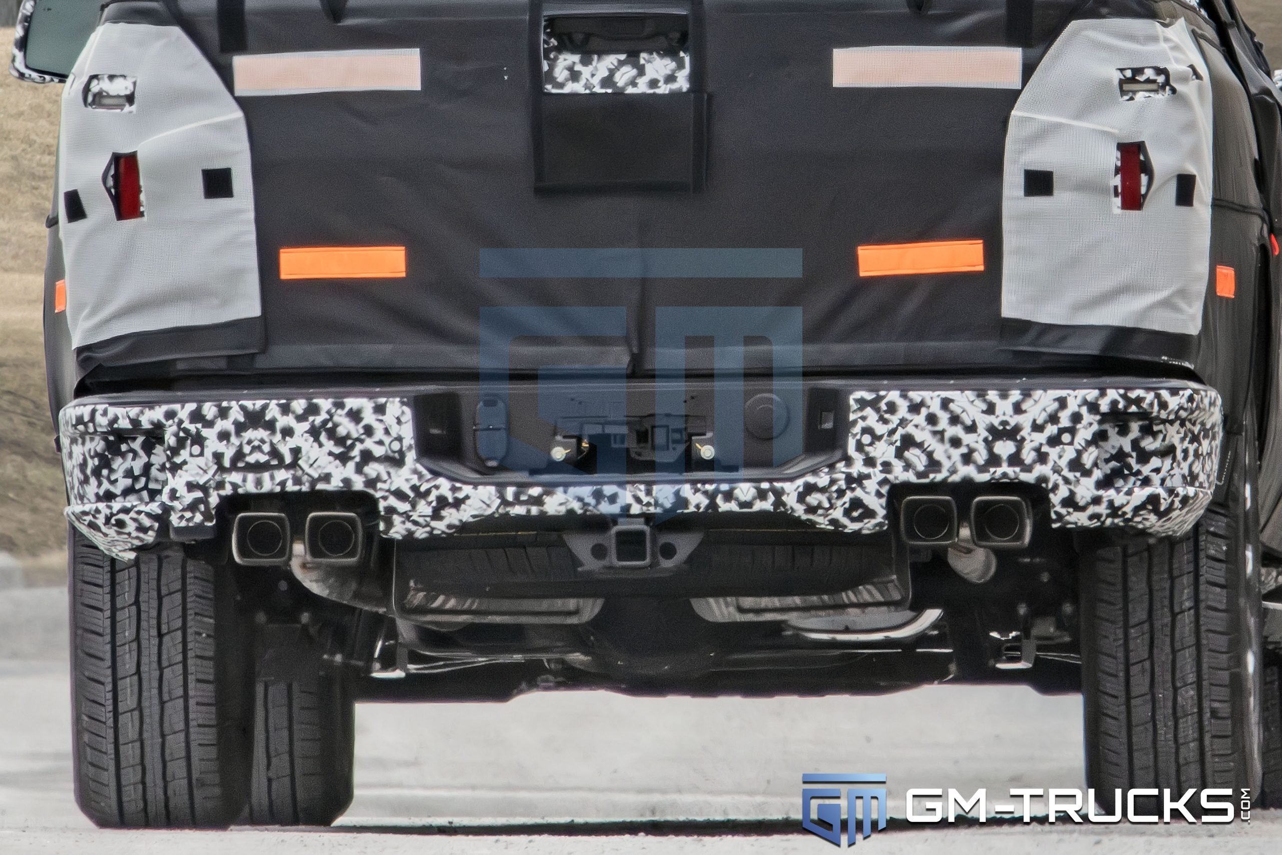 2027 Chevy Silverado Spied with Quad Exhaust, Off-Road Upgrades & High-Tech Interior 3 Close-up of the 2027 Chevrolet Silverado prototype’s rear end, featuring a quad-tip exhaust setup, revised bumper design, and hidden taillights.