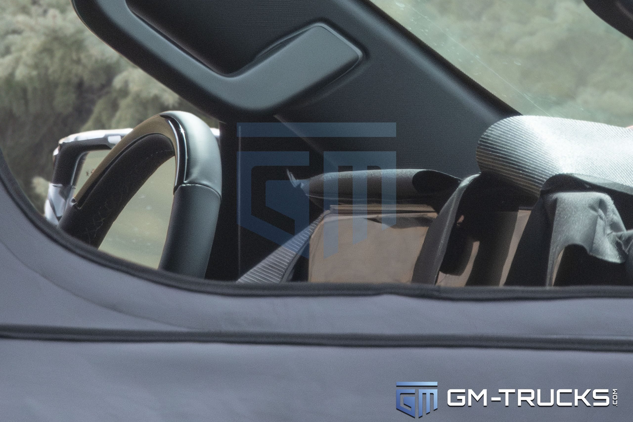 2027 Chevy Silverado Spied with Quad Exhaust, Off-Road Upgrades & High-Tech Interior 4 Close-up of the 2027 Chevrolet Silverado prototype interior, showing a large digital display and redesigned steering wheel.