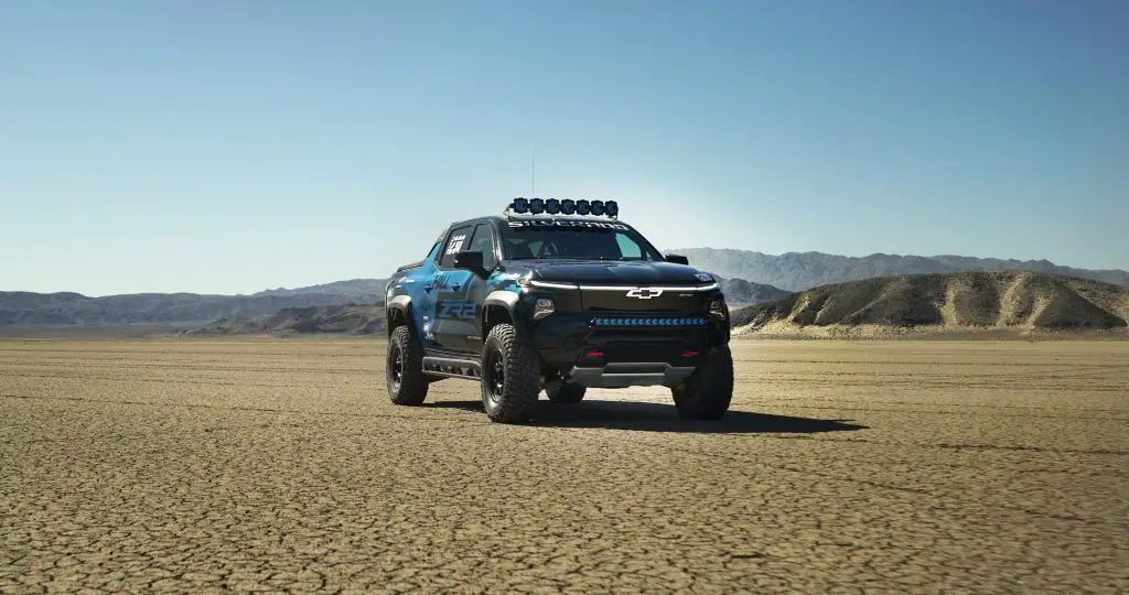 The Chevrolet Silverado EV ZR2 race truck parked on a dry lake bed, built for extreme off-road endurance racing like the Mint 400.
