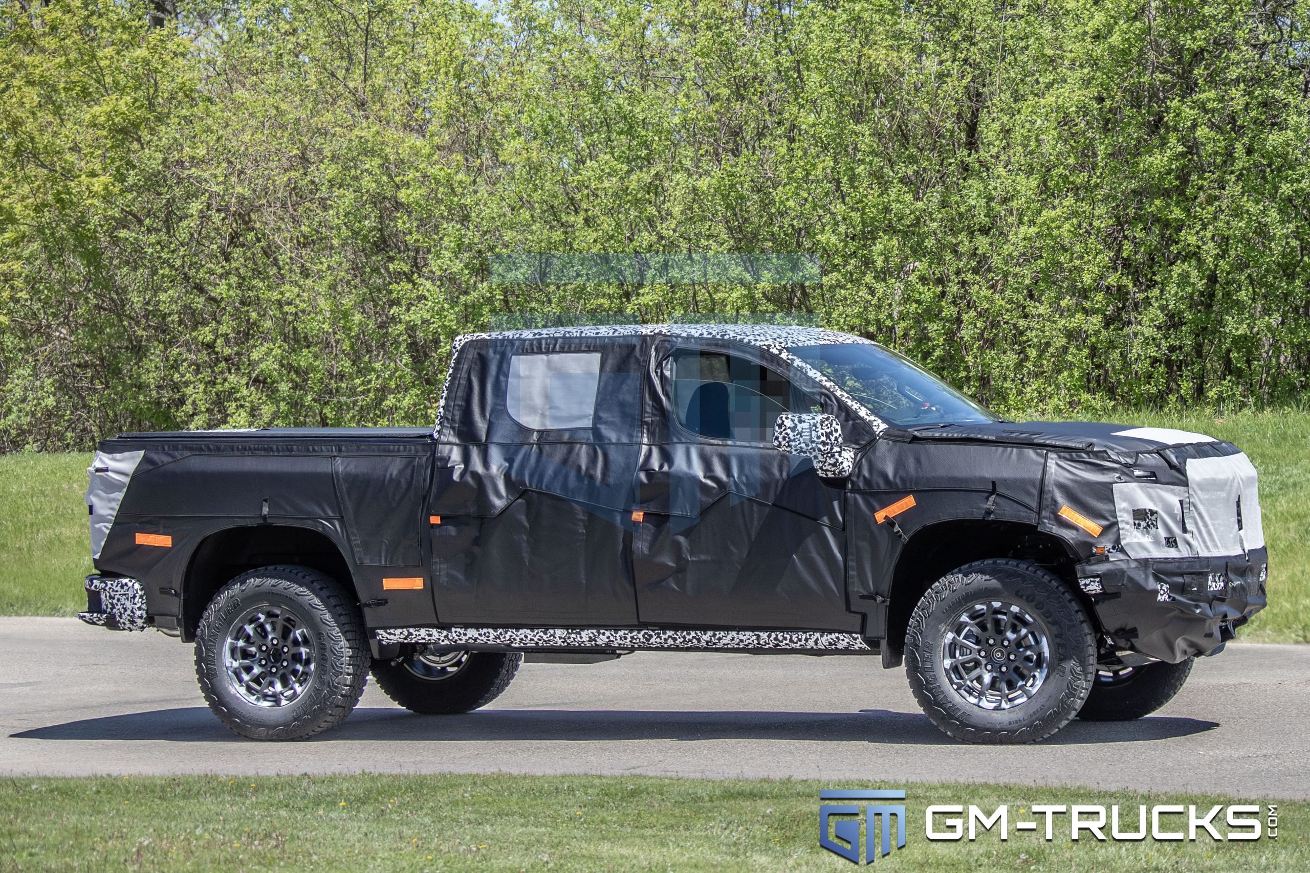 2027 Chevrolet Silverado ZR2 Spy Shots Reveal Major Off-Road Upgrade 2 Side view of camouflaged 2027 Chevrolet Silverado ZR2 prototype riding on 35-inch tires during road testing