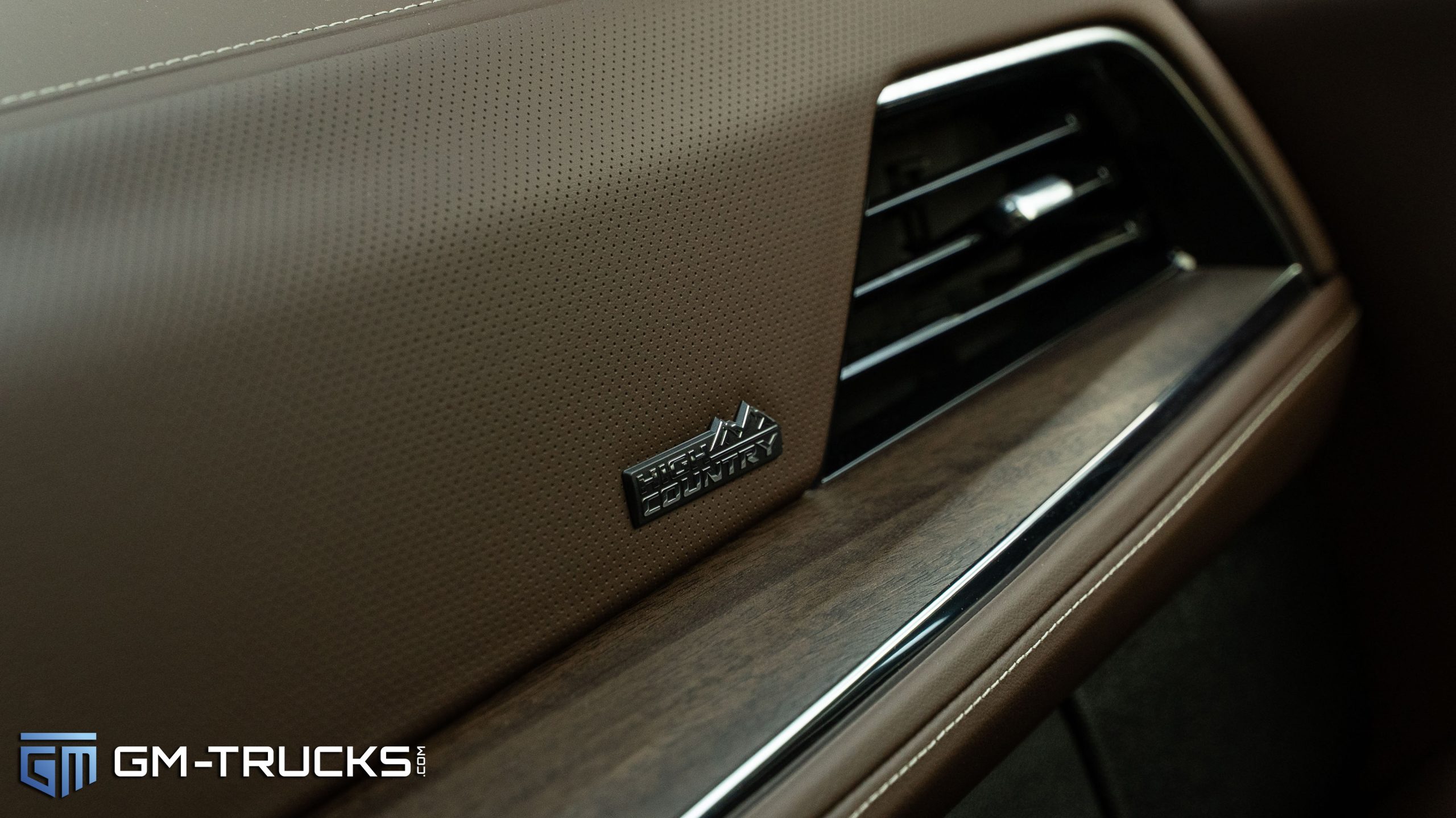 I Drove The Most Expensive Tahoe Ever Sold - 2025 Chevy Tahoe High Country Review 9 High Country badge on the dashboard of the 2025 Chevrolet Tahoe with mocha leather and wood trim