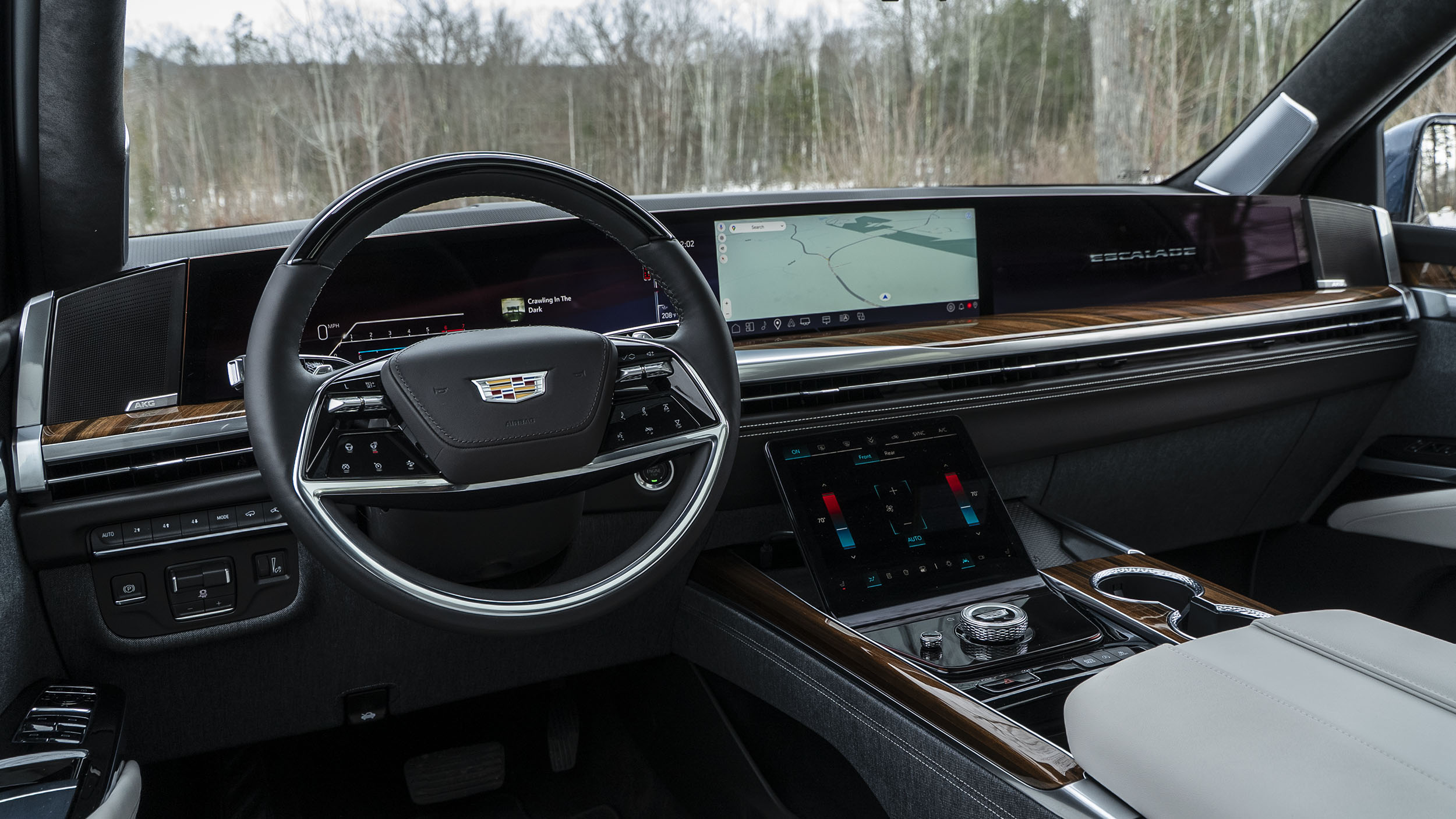 Power Open Doors, Night Vision & 55-Inch Displays: 5 Wild Tech Features on the 2026 Escalade 3 Interior view of the 2026 Cadillac Escalade dashboard from the driver's seat, showing the massive 55-inch curved display spanning door to door, displaying navigation and system info, with the leather steering wheel in the foreground.