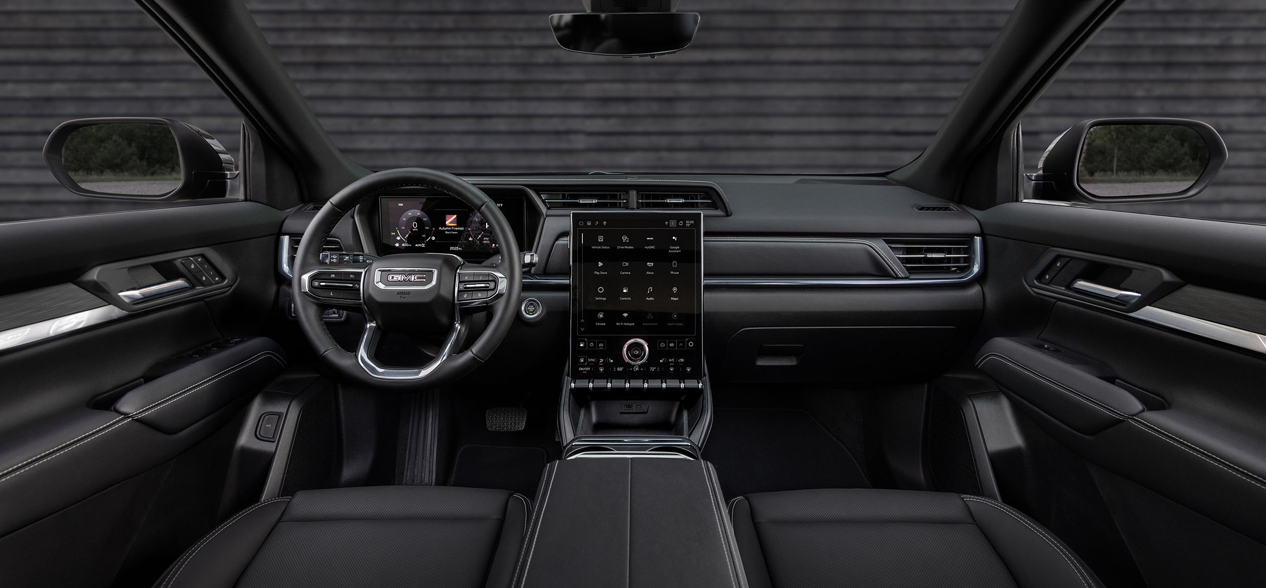 2027 GMC Terrain Drops the CVT and Adds Tesla-Like Connected Dash Cams 2 A wide view from the back seat looking forward at the dashboard of the new GMC Terrain, featuring a large 15-inch portrait-oriented infotainment screen and an 11-inch digital gauge cluster.