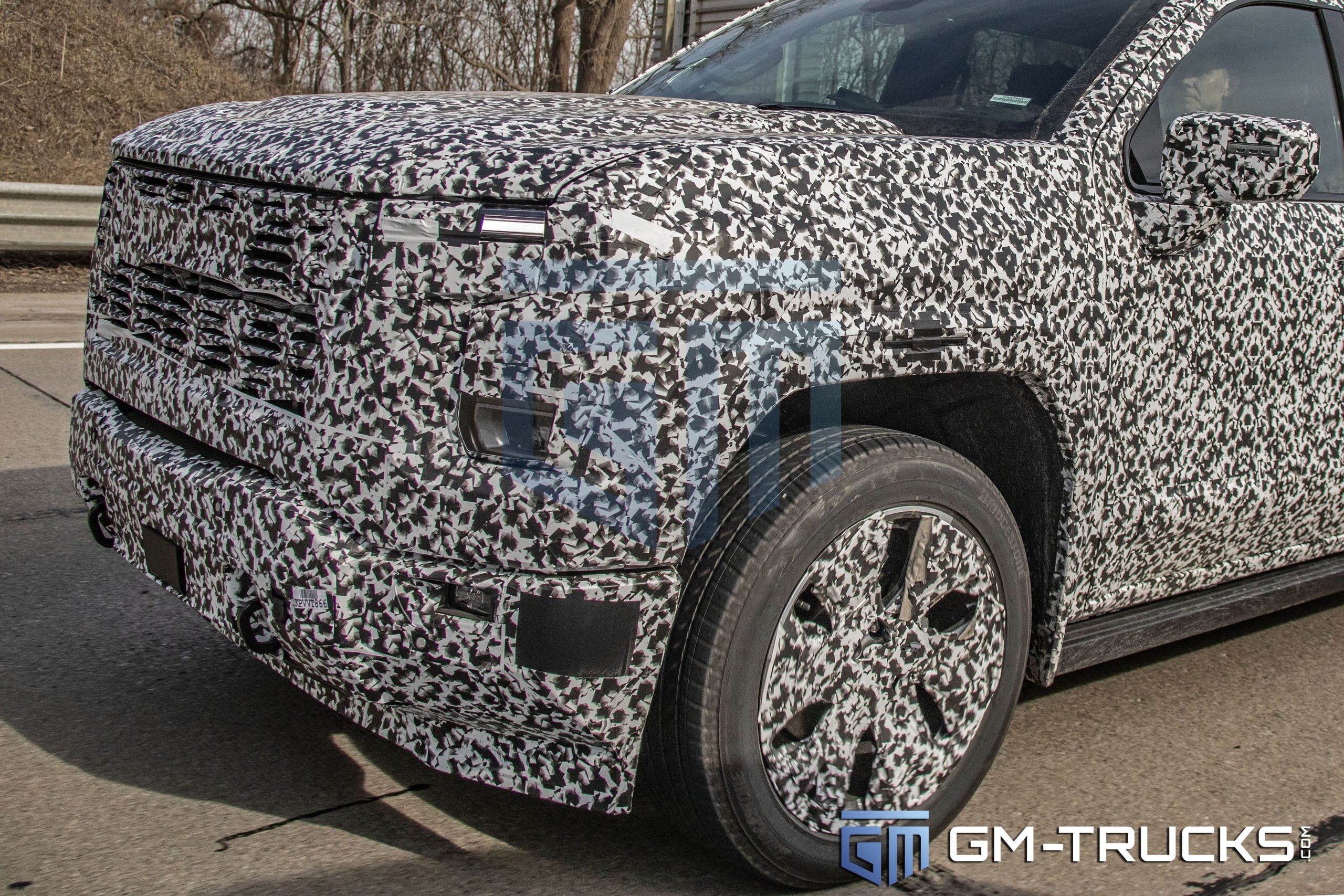 SPY SHOTS: 2027 GMC Sierra 1500 Denali & AT4 Break Cover – Full Interior Exposed! 3 Alt Text (Accessibility & Core SEO): A camouflaged next-generation 2027 GMC Sierra 1500 Denali prototype in a front three-quarter view, showing the aggressive new front fascia and production lighting.