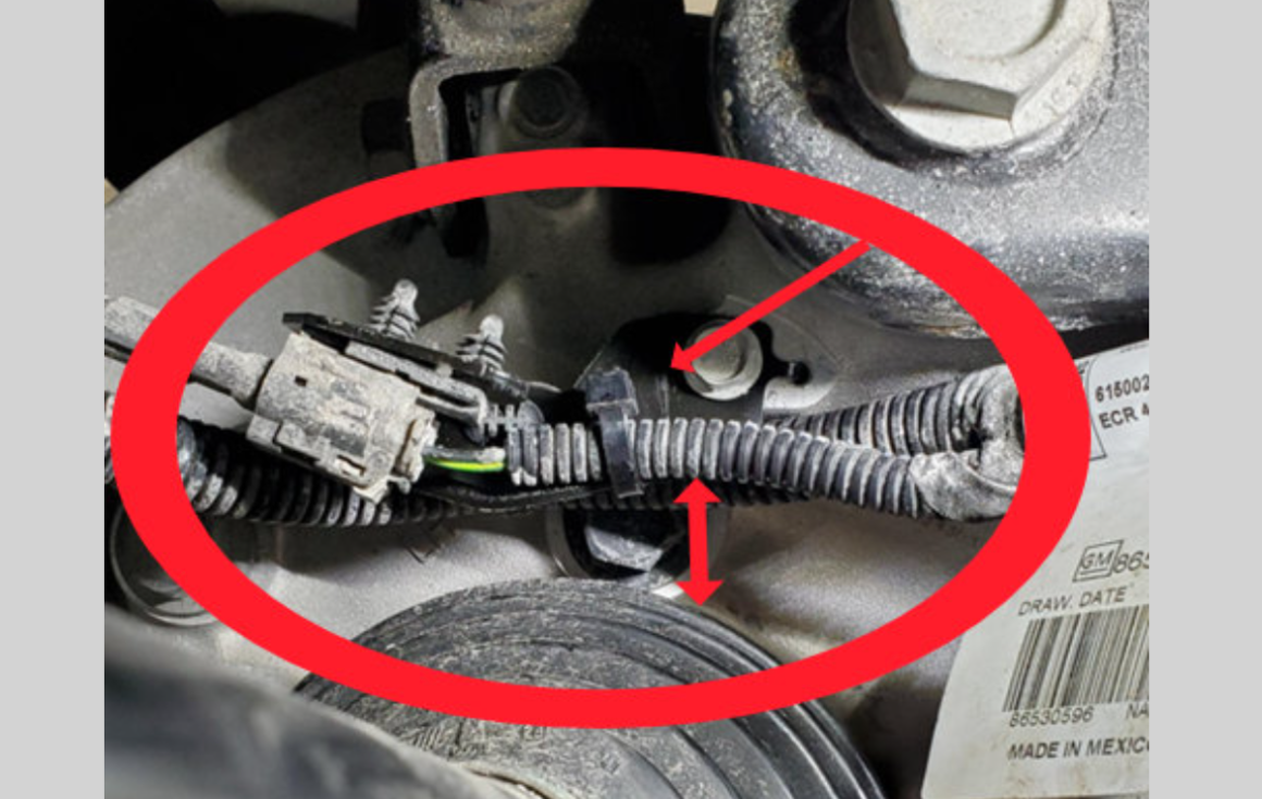 The Tiny Sensor Causing Big Problems on 2021-2025 GM Full-Size SUVs 3 Close-up of a newly installed metal bracket securing a corrugated wiring harness with a zip-tie, showing a clear gap above a rubber half shaft boot.