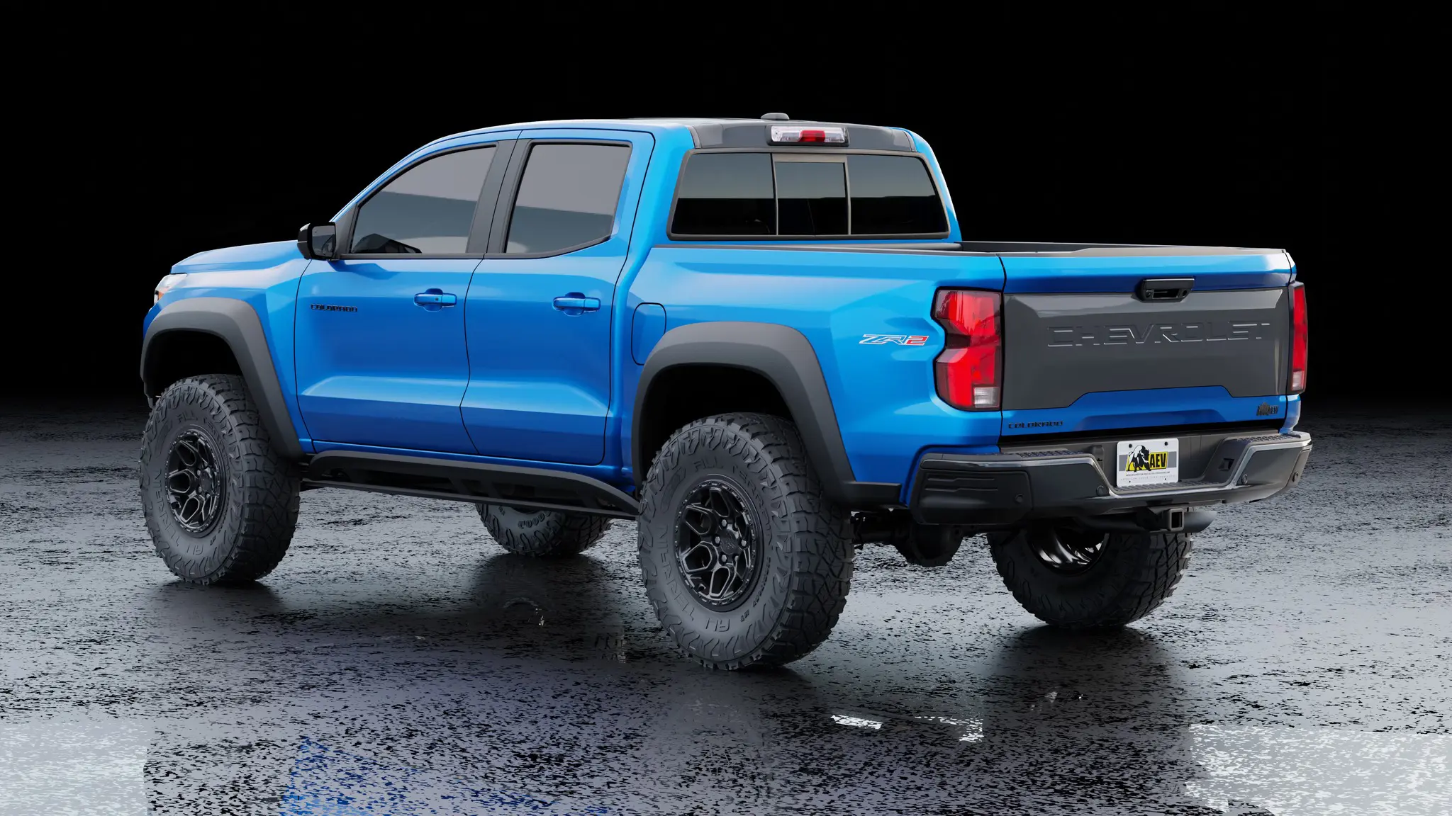 AEV’s Warranty-Backed Conversions Turn Your Colorado ZR2 / Canyon AT4X Into a 35-Inch Tire Off-Road Beast 4 Rear three-quarter view of a blue Chevrolet Colorado ZR2 equipped with the AEV 35-inch tire turn-key conversion package, showing AEV wheels, HighMark flares, and custom tailgate graphics.
