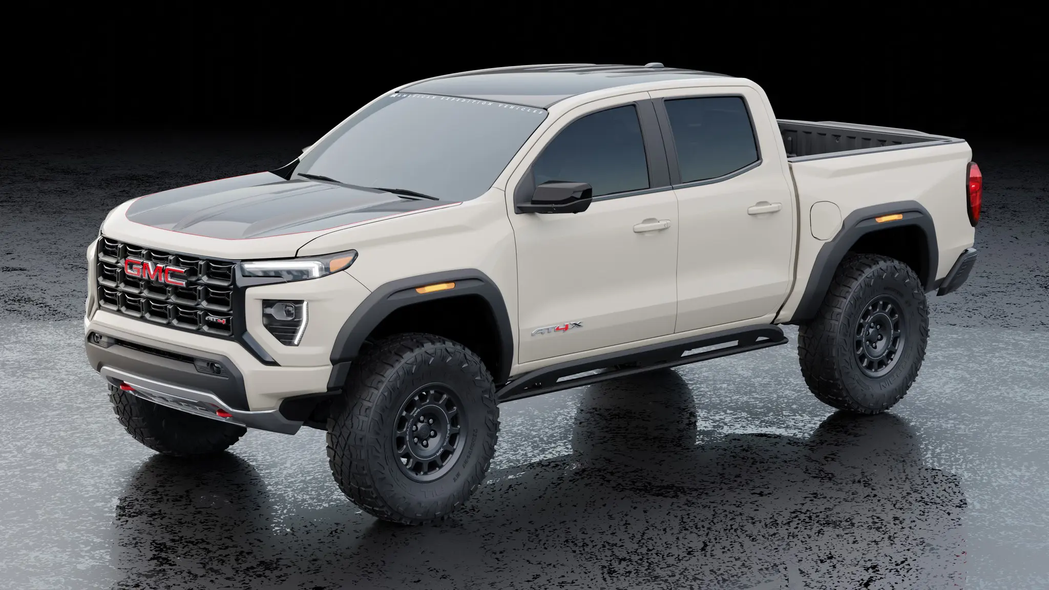 AEV’s Warranty-Backed Conversions Turn Your Colorado ZR2 / Canyon AT4X Into a 35-Inch Tire Off-Road Beast 3 Front three-quarter view of a light tan GMC Canyon AT4X equipped with the AEV turn-key conversion package, highlighting the HighMark fender flares, 35-inch tires, Salta XR wheels, and custom hood graphics.