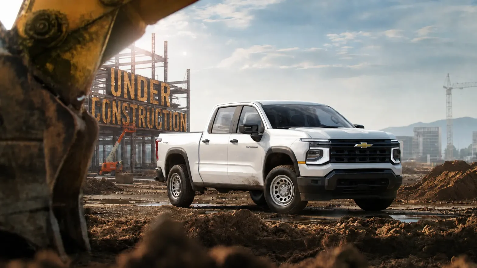 A white 2027 Chevrolet Silverado Work Truck at a construction site, with an "Under Construction" sign built into the scaffolding behind it.
