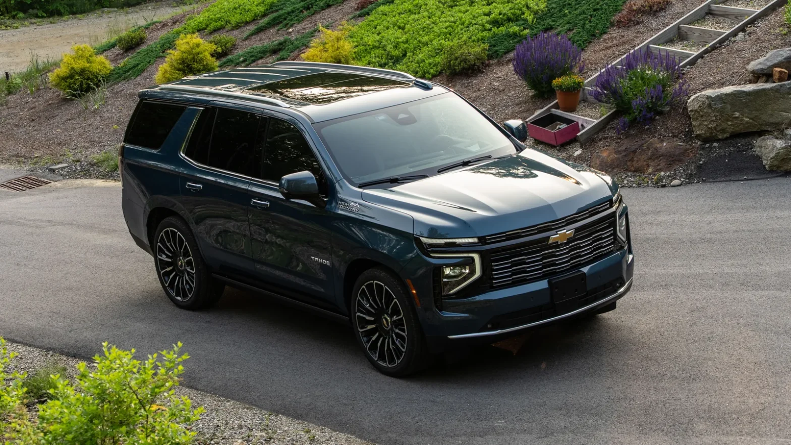 2025 Chevrolet Tahoe High Country in blue parked on a driveway, front three-quarter view