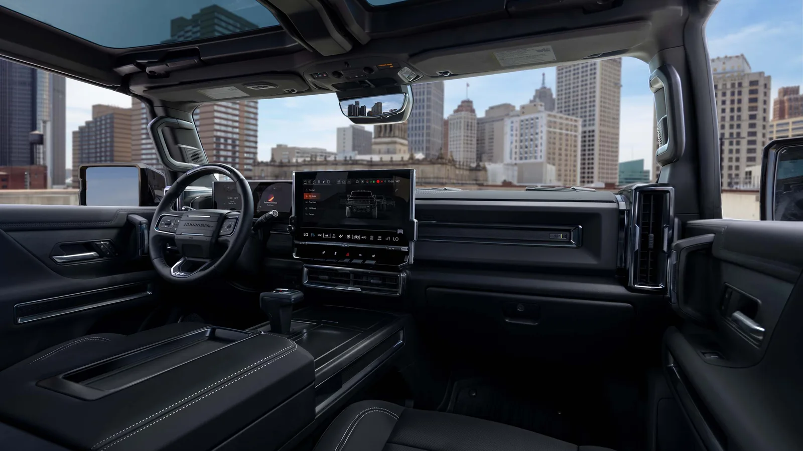 Hummer Turns 25 and GMC Brought the H2's Yellow Back 6 Interior of the 2027 GMC HUMMER EV showing the dashboard, infotainment screen and Infinity Roof with a city skyline outside