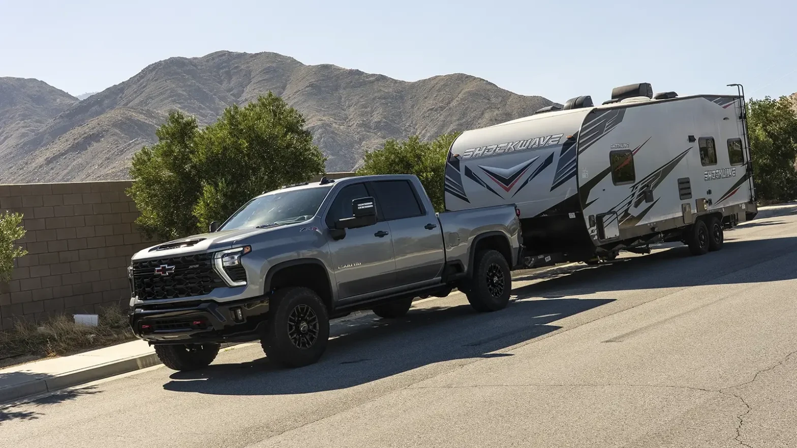 Animated OEM Tail Lamps Jam Trailer TPMS on Silverado HD / Sierra HD 1 Chevrolet Silverado HD pickup truck towing a white travel trailer on a mountain road.